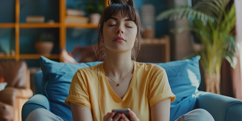 Photo of a woman sitting on a couch with phone