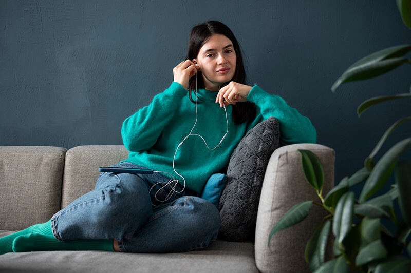 Photo of a woman listening to music on a sofa