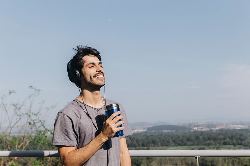 Photo of a man drinking from a thermos