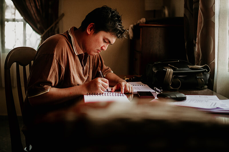 Photo of a man sitting at a table at home