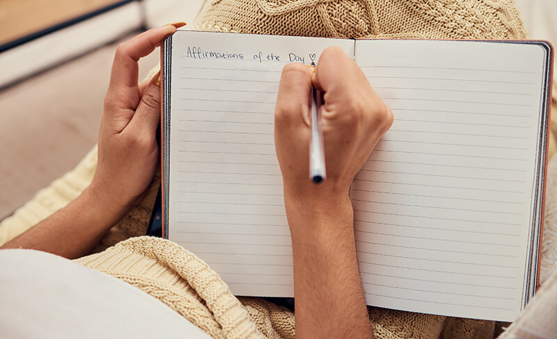 A photo of woman hands writing in a journal