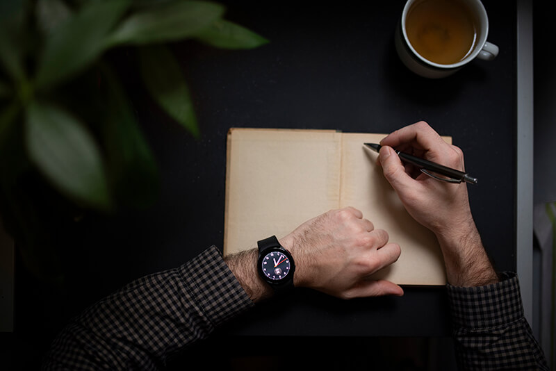 A photo of a person writing in a journal