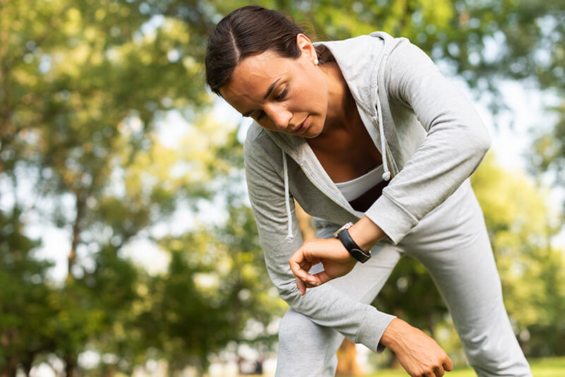 A photo of a woman checking her smartwatch in sports wear
