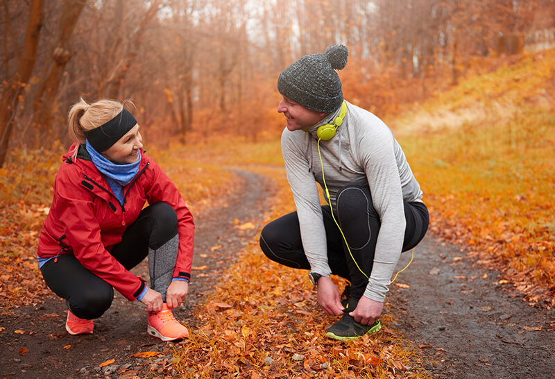 A photo of runners talking on a trail in autumn
