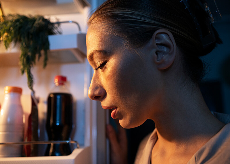 Photo of a woman looking inside a refrigerator