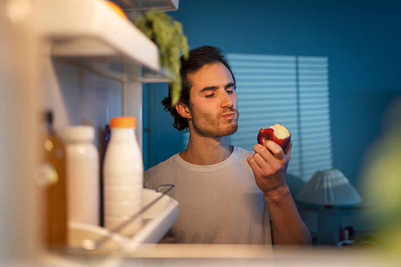 A photo of a man eating an apple