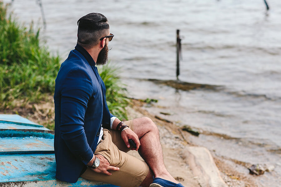Photo of a man looking into the distance by the shore