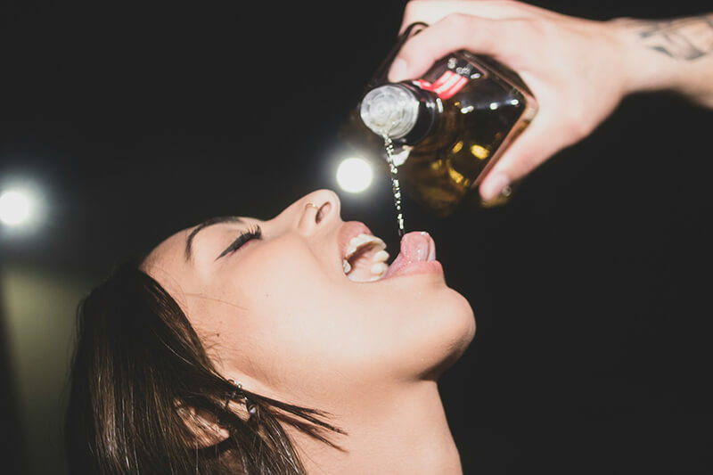 A photo of a woman drinking straight out of a bottle