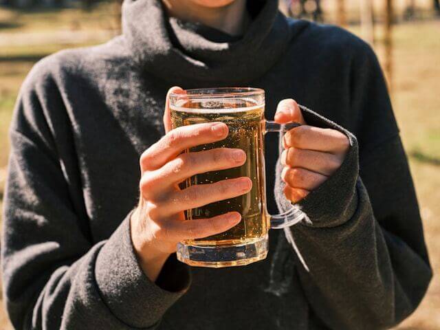 A photo of a man holding a beer mug with both hands