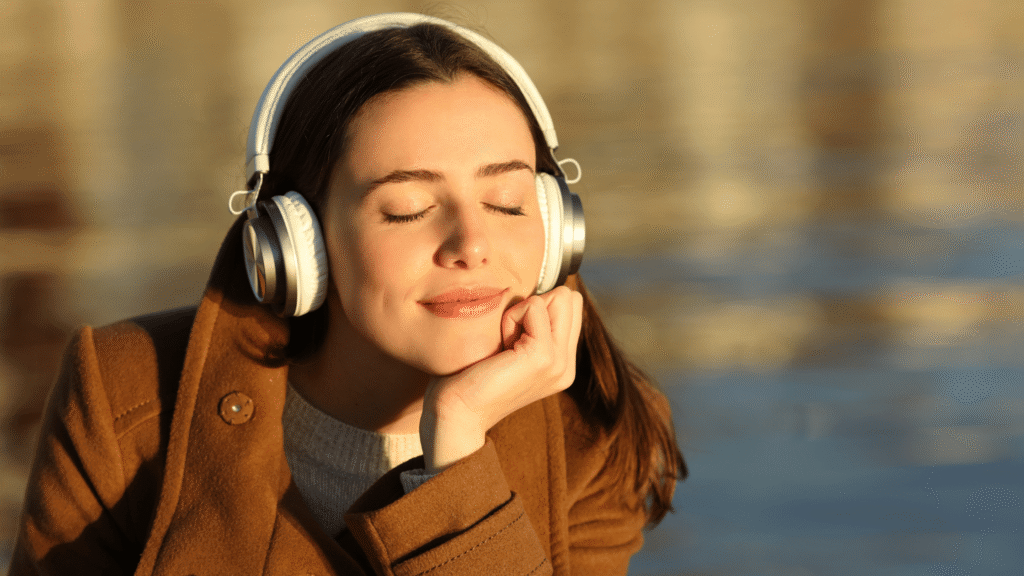 Serene young woman in meditation pose wearing headphones, eyes closed in calm relaxation, symbolizing neuroplasticity and gentle suggestion to lower alcohol urges via UM.app