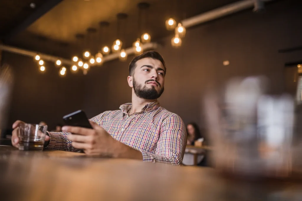 man considering the true cost of drinking alcohol