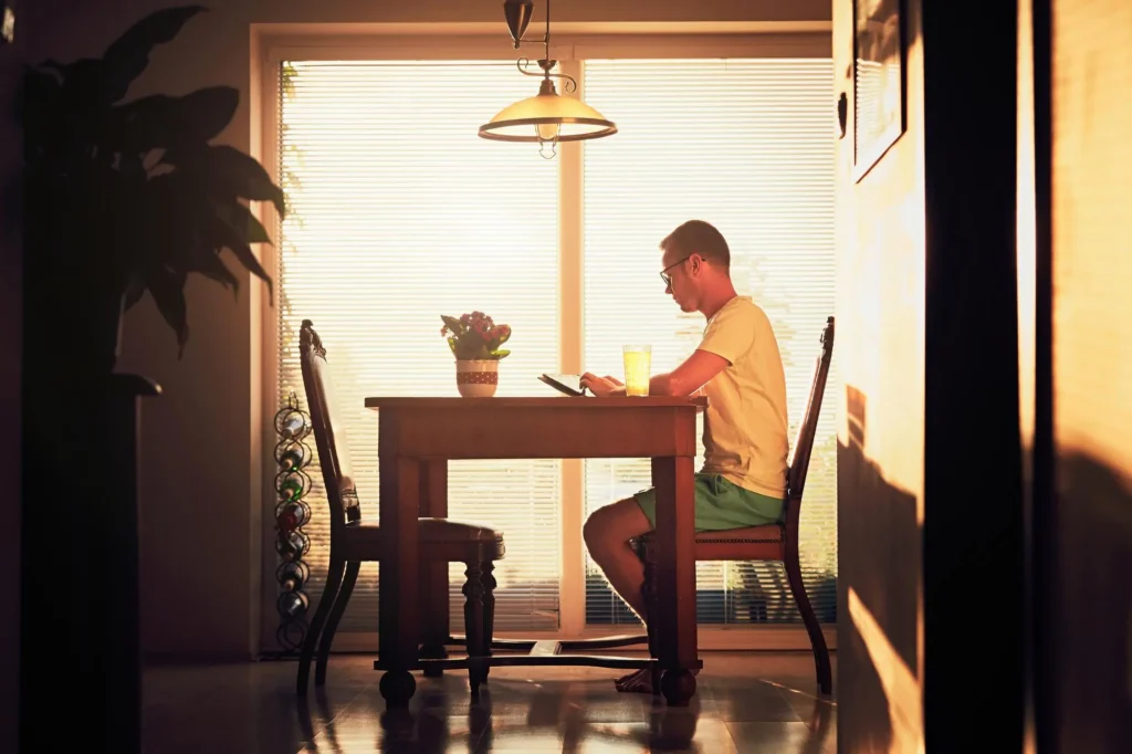 Man sitting alone in a parked car at dusk, looking through the windshield as he reflects on his relationship with alcohol